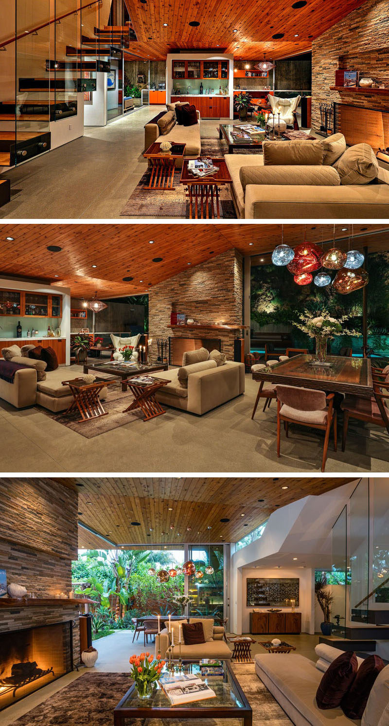 This home, designed by SPACE International, has a large living room that shares the space with the dining area. The wooden ceiling flows from the outside of the home to the interior, joining the two two areas to create a single cohesive look.