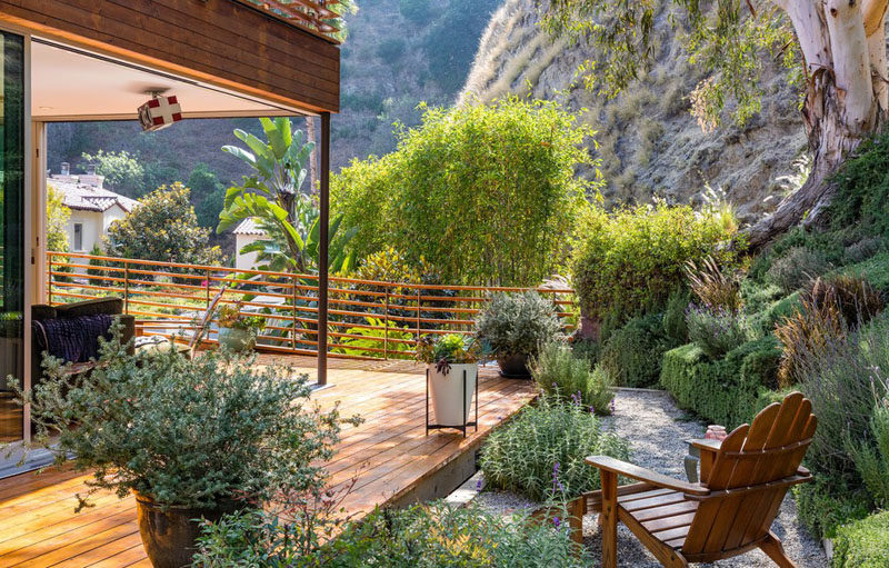 A small gravel area of the garden is home to a single chair, surrounded by greenery.