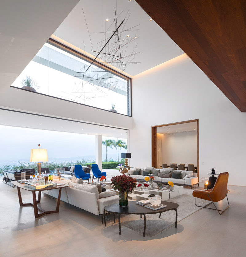 This living room has a large delicate sculptural piece hanging above it.