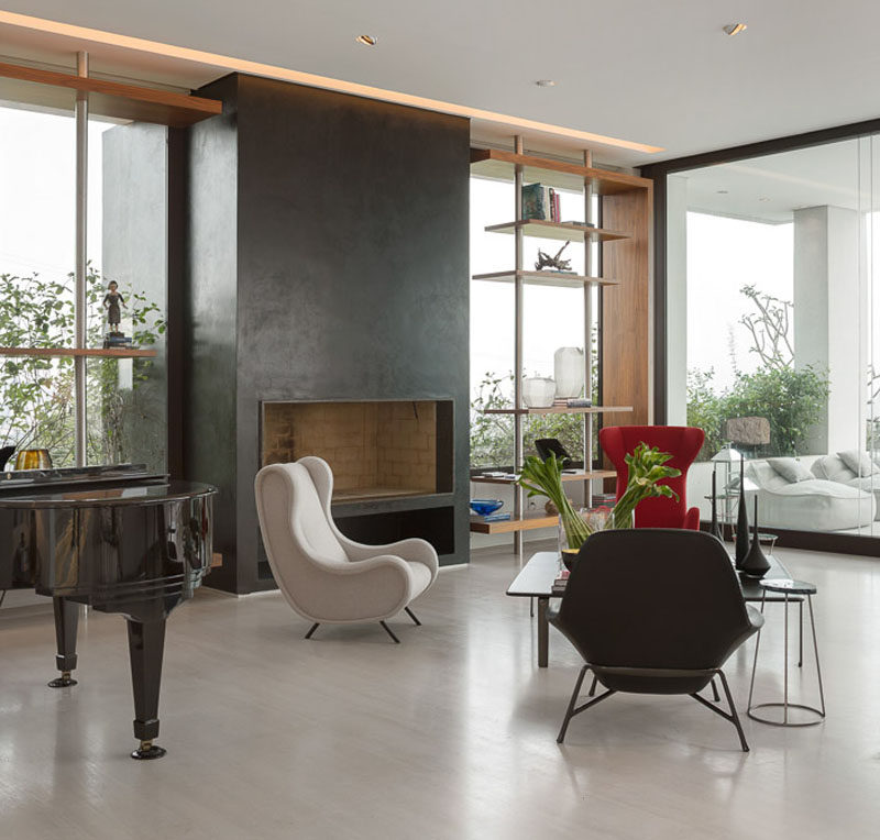 This large grey fireplace surround is flanked by custom shelving either side.