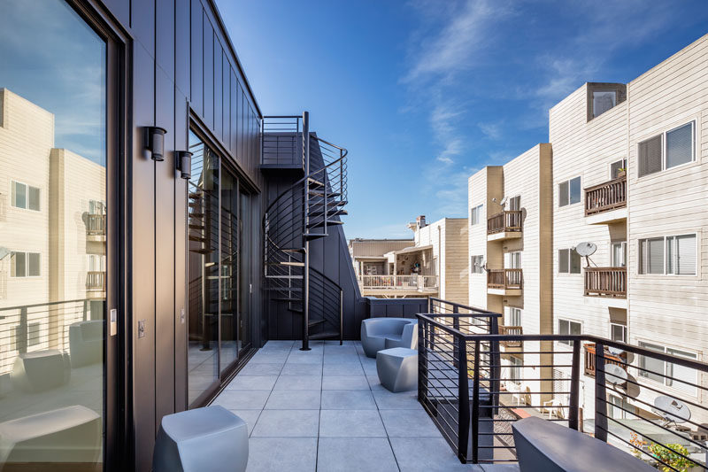 This outdoor balcony has various spaces for relaxing, and spiral stairs that lead to the rooftop.