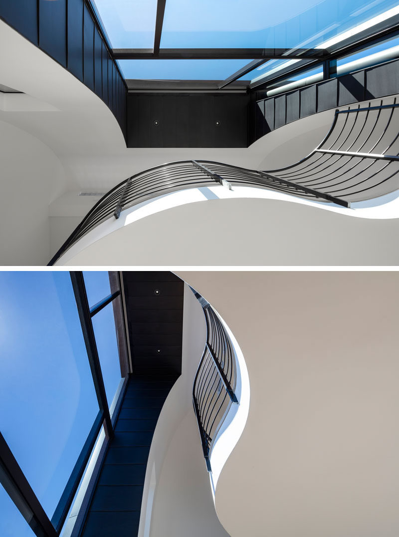 Black railings on a mezzanine match the black window frames in this apartment building.