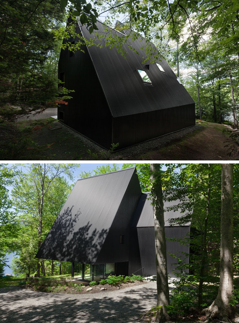 This black cottage with a sloping roof line is surrounded by a Hemlock forest in Quebec, Canada.