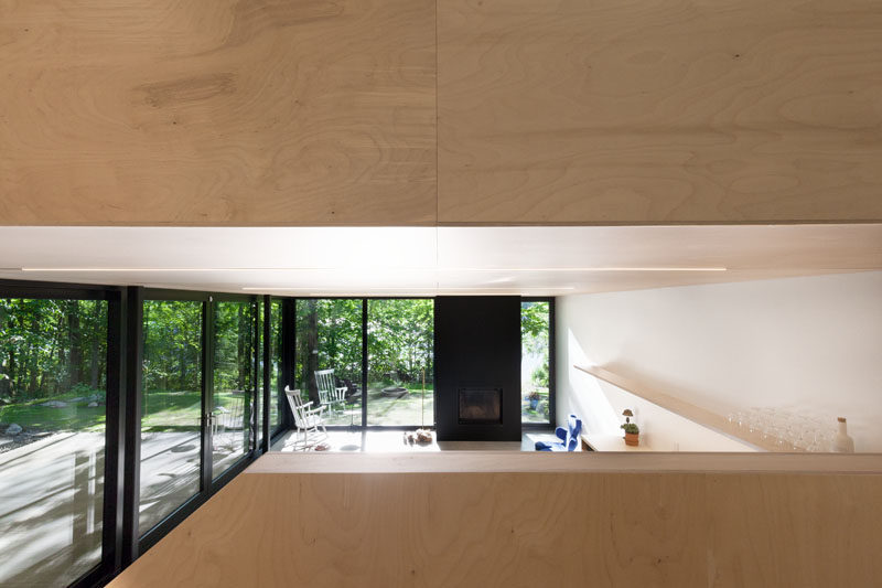 The black fireplace matches the black window and door frames in this Canadian cottage.