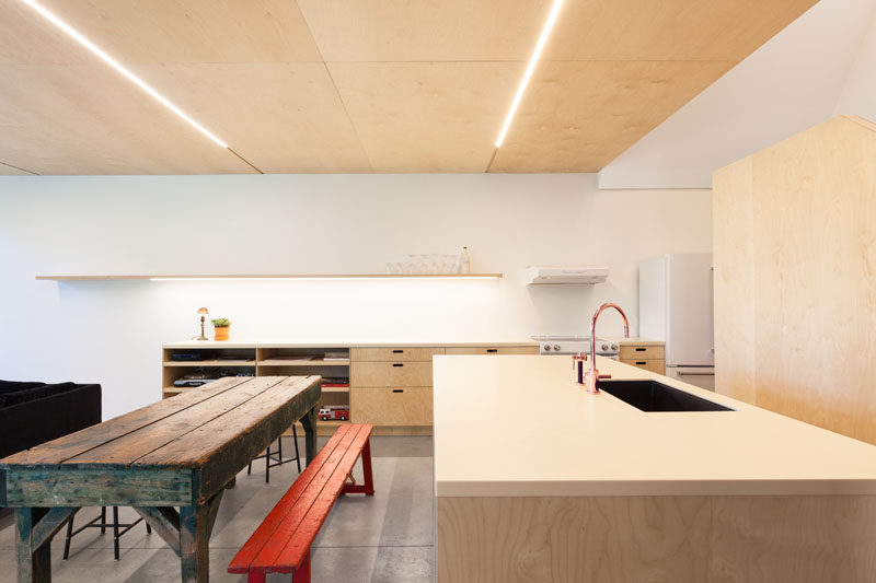 This kitchen has been kept simple, and a shelf along the wall hides additional lighting.