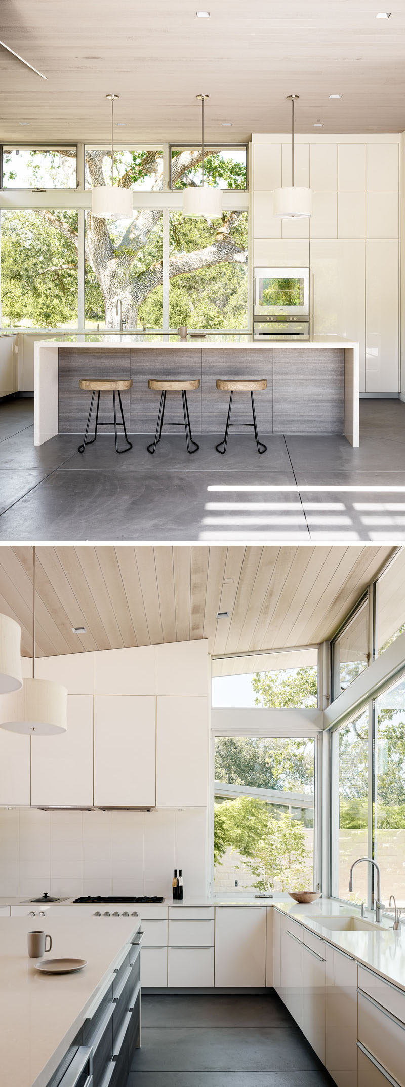 This kitchen is full of white cabinetry, has a large kitchen island with seating, windows that face a courtyard and cedar-clad ceilings.