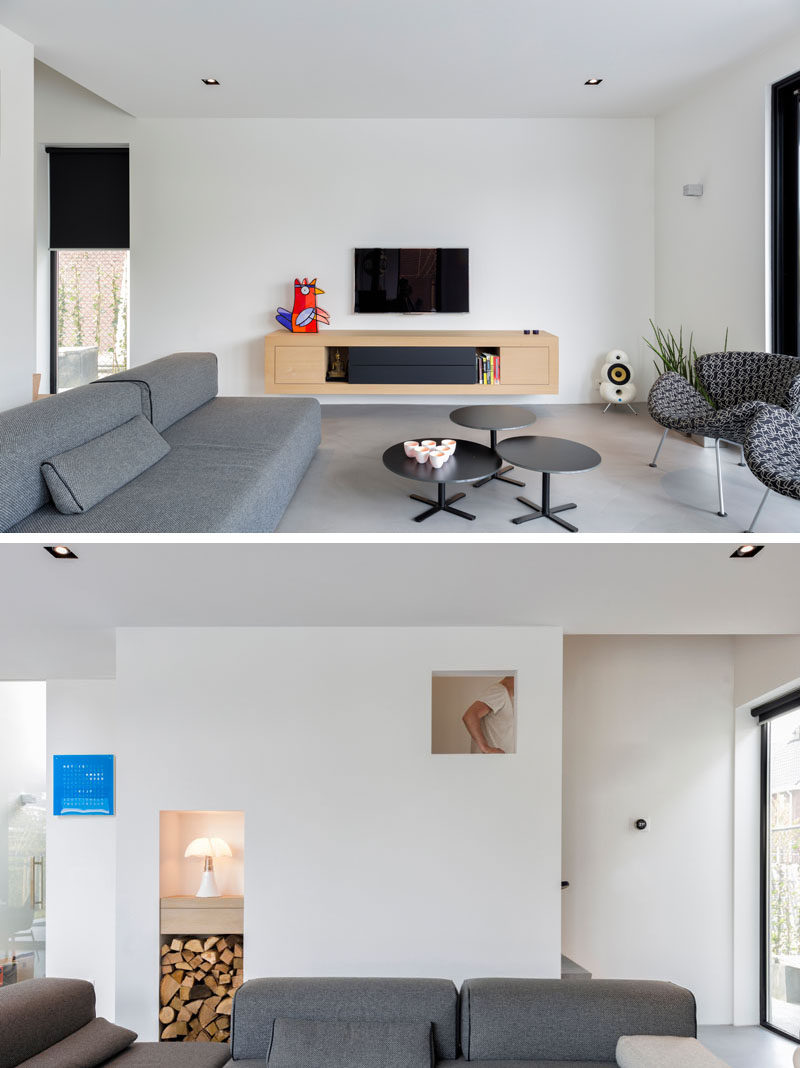 This living room has been kept minimal in its design, with a floating unit attached to the wall. There's also a built-in cubby for wood storage.