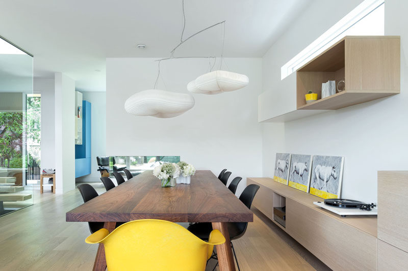 In this dining room, white walls are broken up with wooden cabinetry and yellow accents add some fun touches to the room.