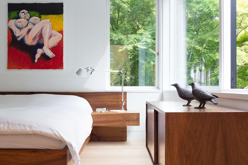 A rich wood bed frame matches the storage cabinet against the wall.