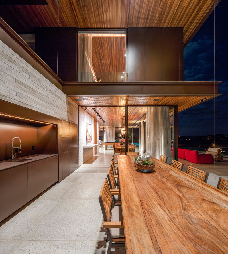 This Brazilian home has an outdoor kitchen and large wooden dining table, perfect for outdoor entertaining.