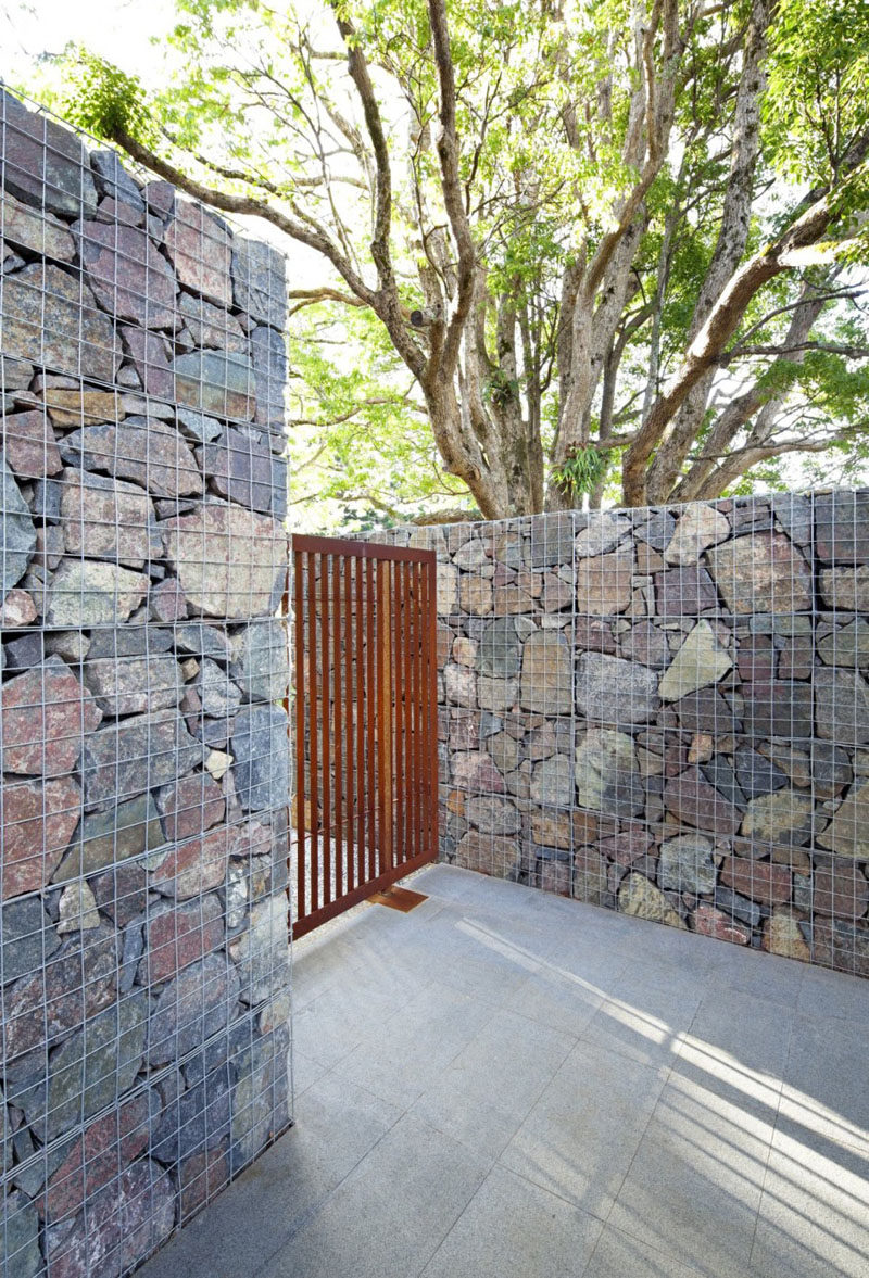 A gabion is a cage filled with rocks, concrete scraps, or really anything you can fit into the wire cage. #Gabion #LandscapingIdeas #FenceIdeas #ModernFence #Architecture #Landscaping