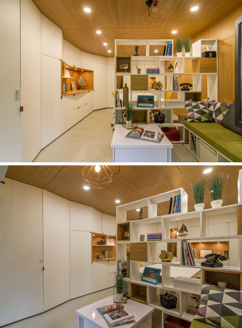 A double-sided bookshelf has been used as a room divider, with some sections blocked off with wooden boxes, providing cubby holes for decorative items.