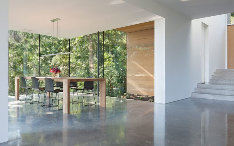 The glass walls that surround this dining room allow for plenty of natural light to flood the room, and at the same time, they provide amazing views of the forest and ocean in the distance.