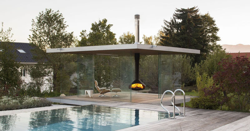 This contemporary glass pool house has uninterrupted views, sliding doors on all sides, a hanging fireplace and a hidden fridge in the floor.