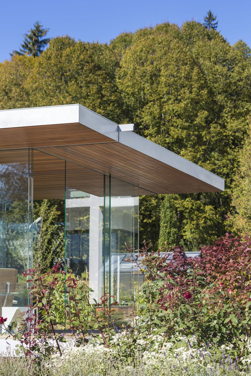 This contemporary glass pool house has uninterrupted views, sliding doors on all sides, a hanging fireplace and a hidden fridge in the floor.