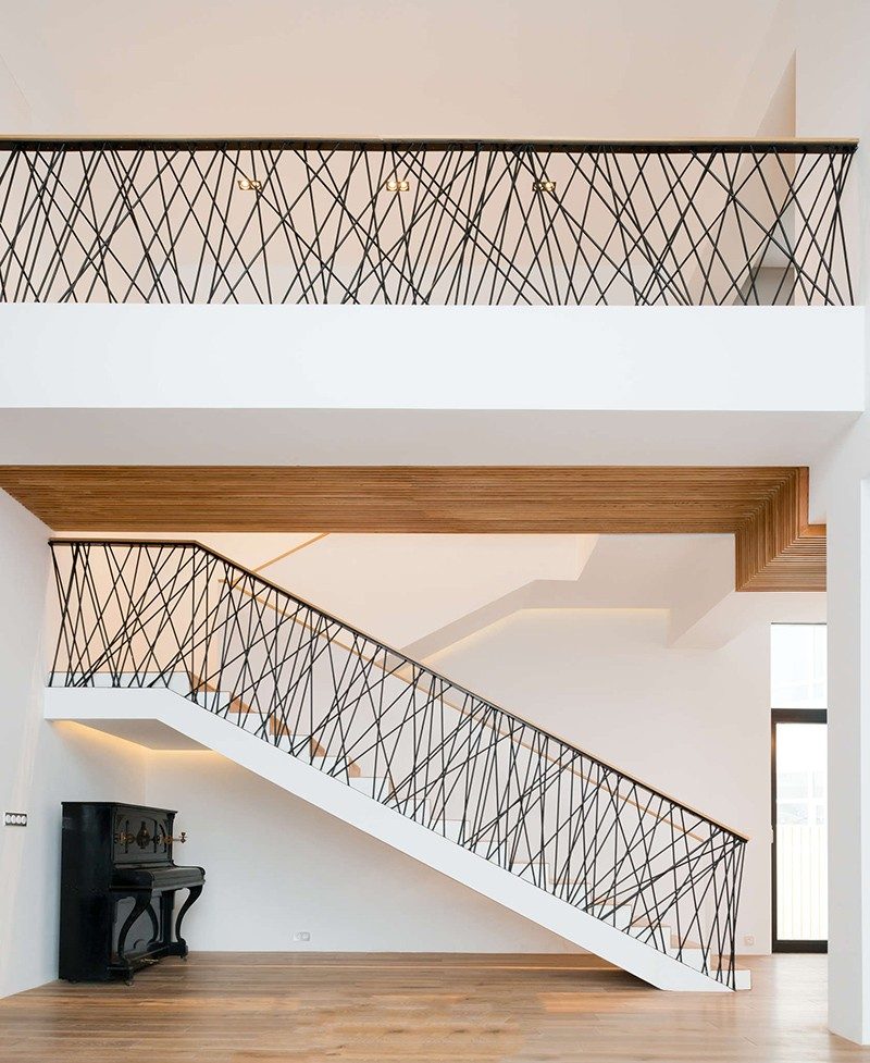 This home features custom railings on the stairs and the top floor, made from randomly placed steel supports that have been powder coated black.