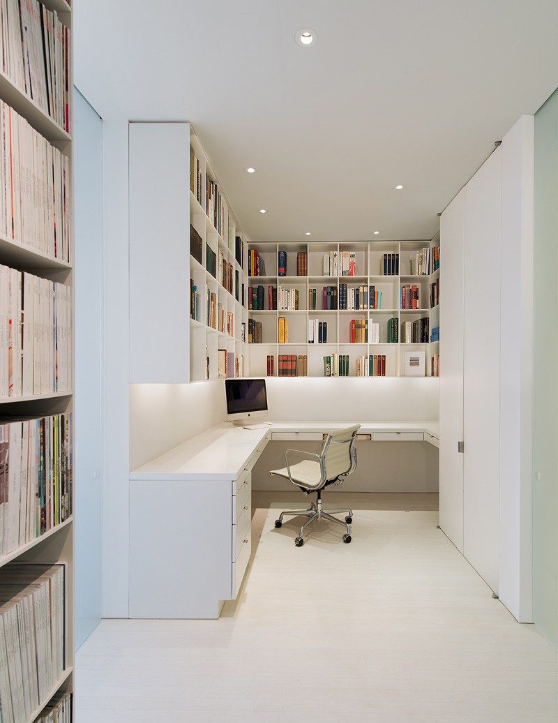 This home office with plenty of storage is in a white themed apartment in Washington DC.