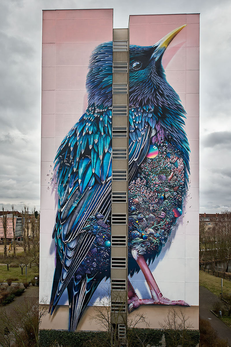 This large colorful mural of a bird can be found on the side of a building in Germany.