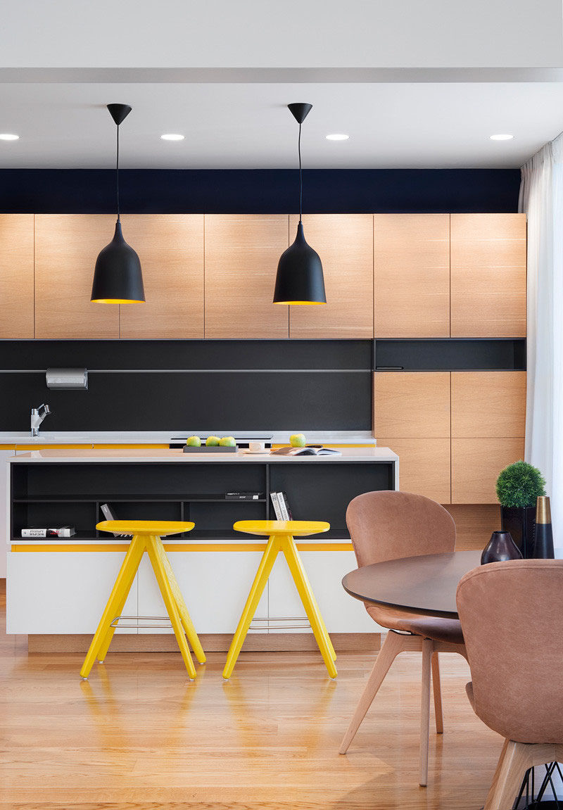 Sunny pops of yellow are found throughout this black and wood kitchen.