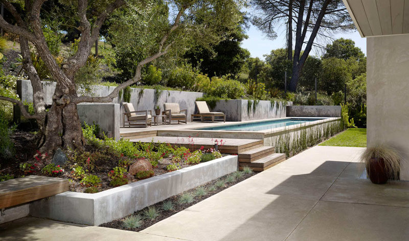 13 Multi-Level Backyards To Get You Inspired For A Summer Backyard Makeover // This backyard is divided into a ground level area with green space and a seating patio, and a second level with a seating area at the same height as the pool.