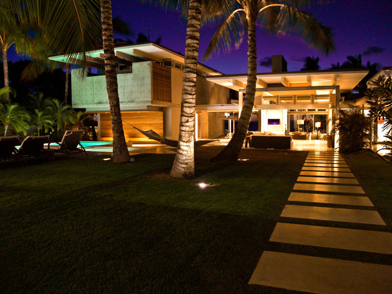 17 Inspiring Examples Where Exterior Uplighting Has Been Used To Show Off A House // Uplighting highlights specific features of this home, such as the palm trees and roof-line.