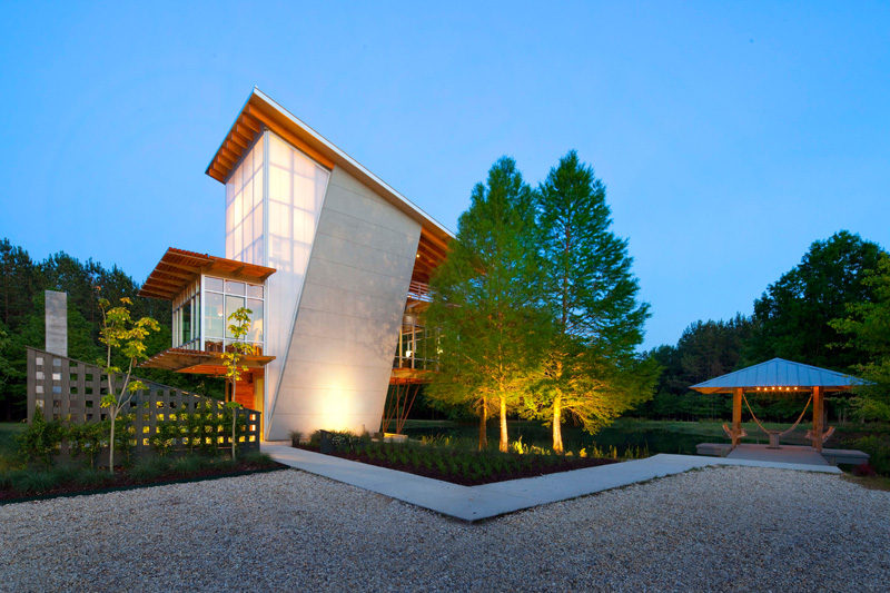 17 Inspiring Examples Where Exterior Uplighting Has Been Used To Show Off A House // Uplighting illuminates the bottom of the large trees and the entry way of this home.