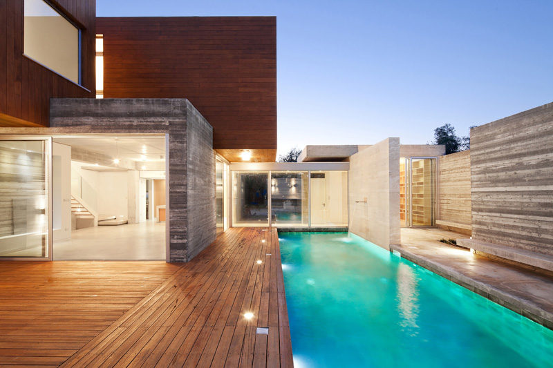 17 Inspiring Examples Where Exterior Uplighting Has Been Used To Show Off A House // Lights built into the pool deck of this house brighten the area surrounding the pool adding an element of safety to the deck.