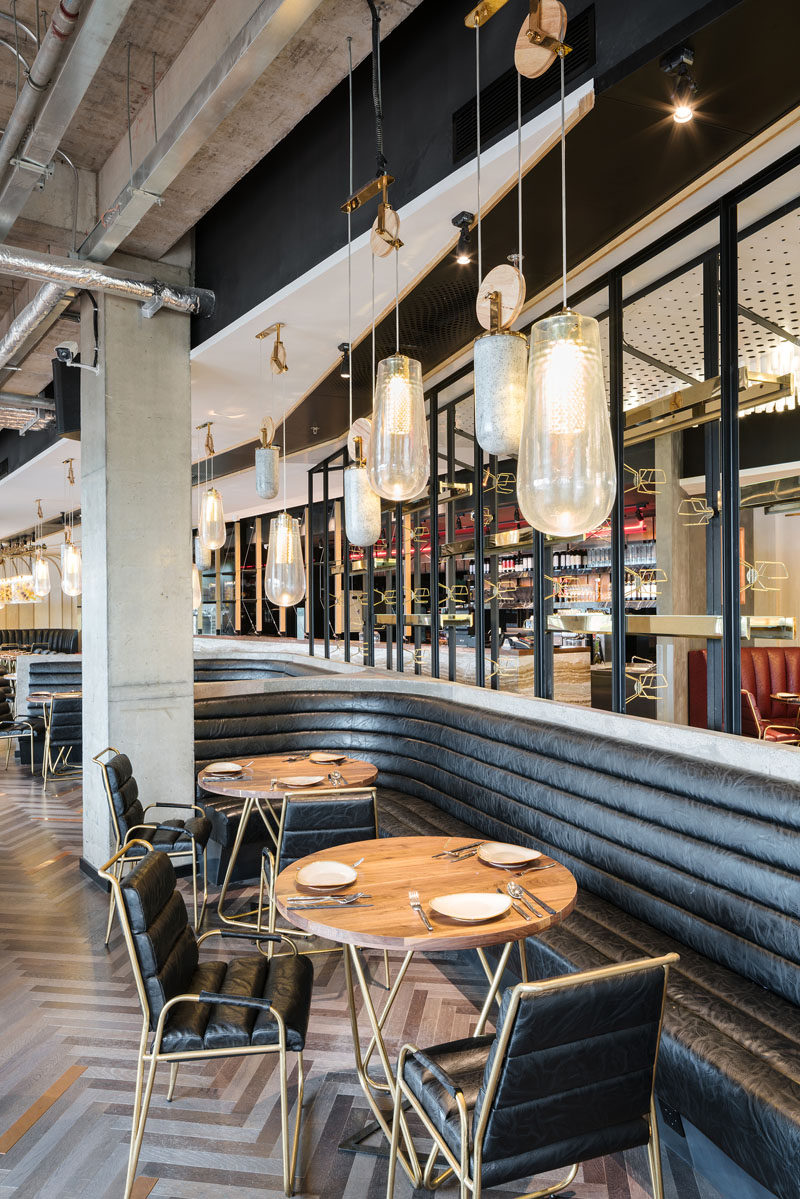 The custom-designed pendant lights that are on a pulley system, consist of a drop pendant light made from cast resin, a counterweight made from cast concrete, and brass details with a diffused COB LED light within.