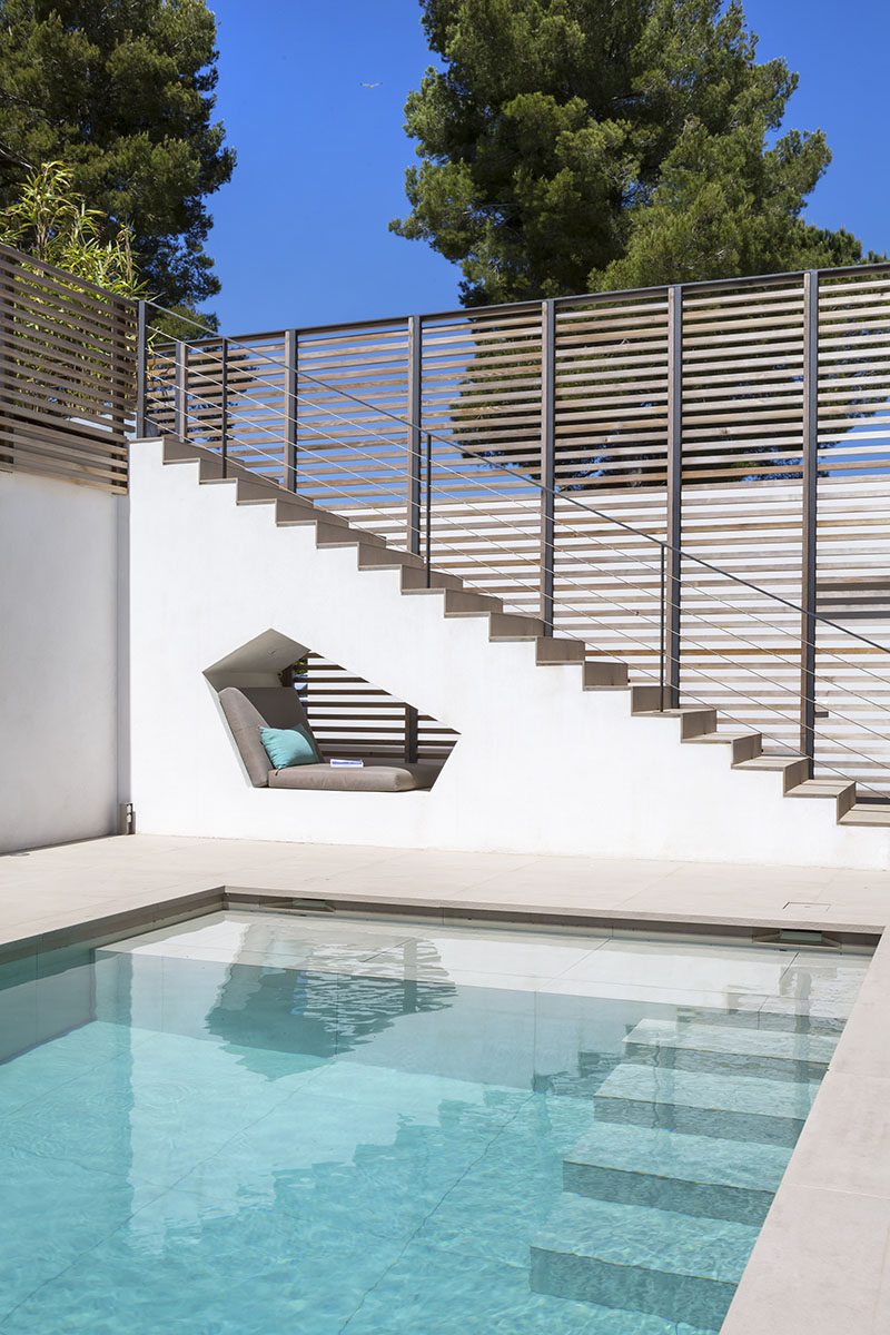 This built-in seating nook is tucked under the stairs by this swimming pool at a house in Saint Tropez.