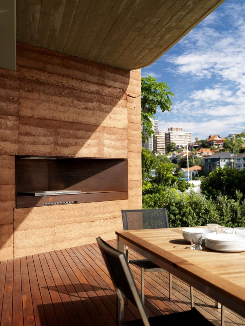 A rammed earth wall surrounds a bbq.