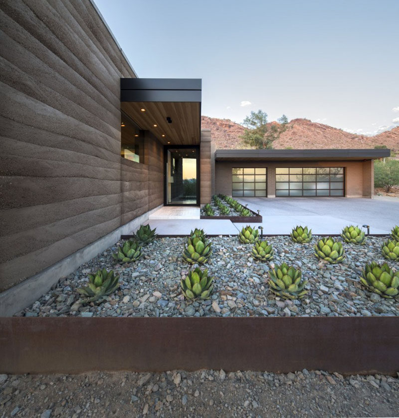 A rammed earth wall complements the planters.