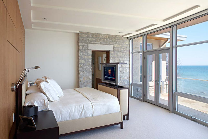 The top of the cabinet at the end of the bed in this Michigan home lifts up to reveal a hidden TV.