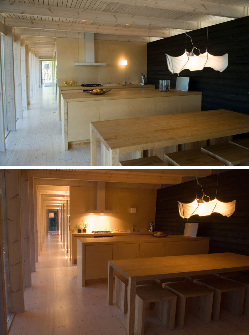 This cottage in Finland has an open dining and kitchen area. Birch plywood contrasts against the stained black wood wall on the right.