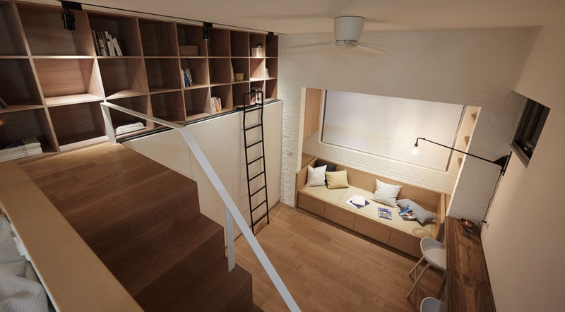 This small apartment has a bookshelf above a wardrobe, that can be reached by ladder.