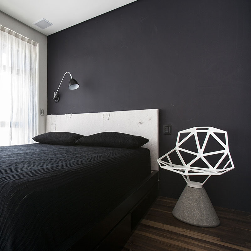 Black bedding matches the black painted wall in this small apartment.