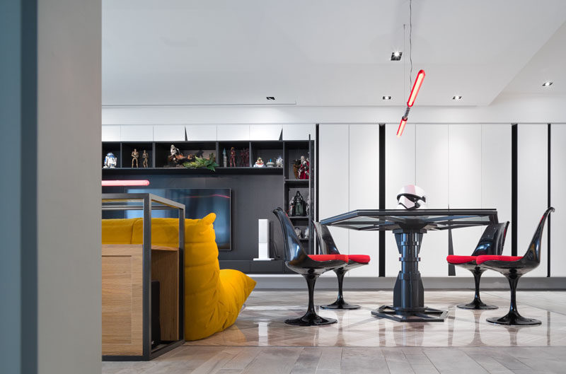 The design of the dining table in a Star Wars inspired apartment, is based on the Imperial Army TIE fighter, with a Darth Maul double-bladed lightsaber chandelier.