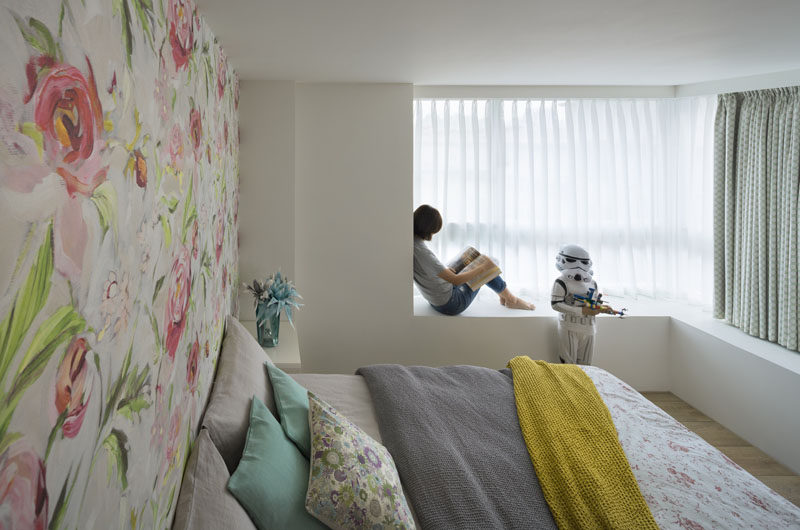 In this bedroom, the colors are a soft tone and there's a built-in bench next to the window.