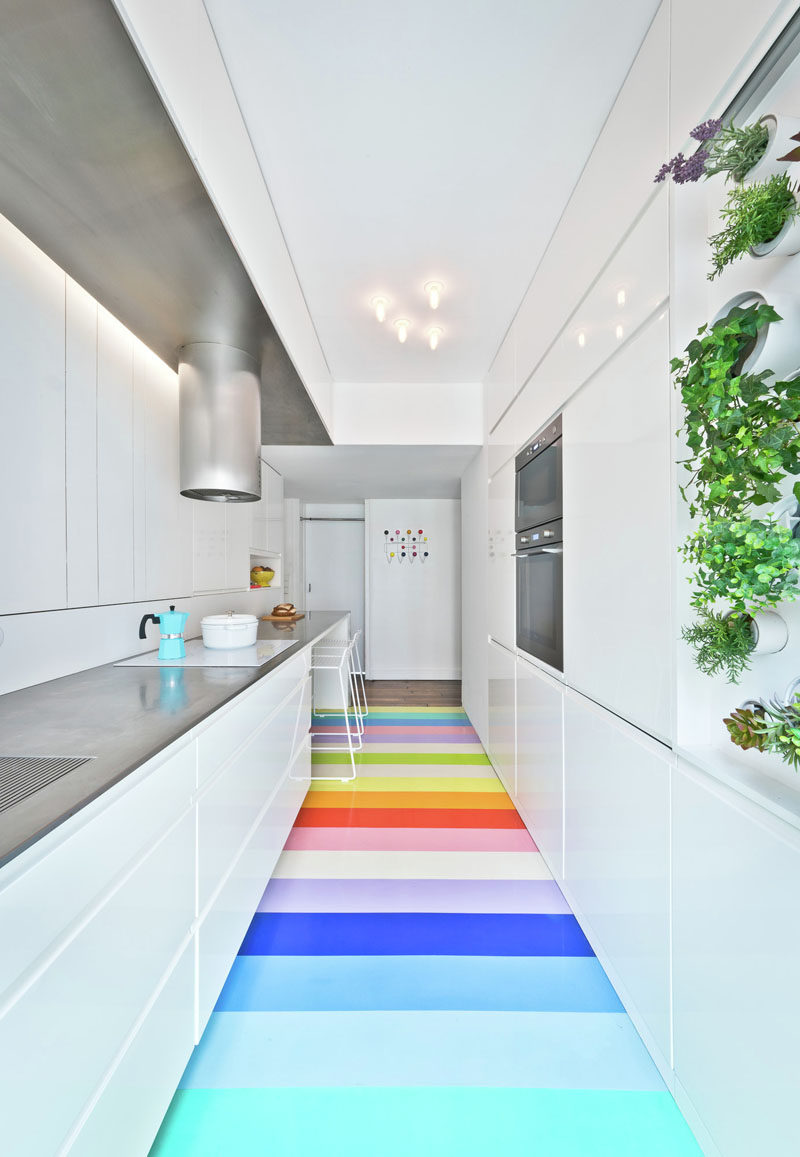 7 Examples Of Striped Floors In Contemporary Homes // 25 bright strips of natural rubber in 14 different colors add a whimsical touch to this modern kitchen and bring in some fun to the very white kitchen.