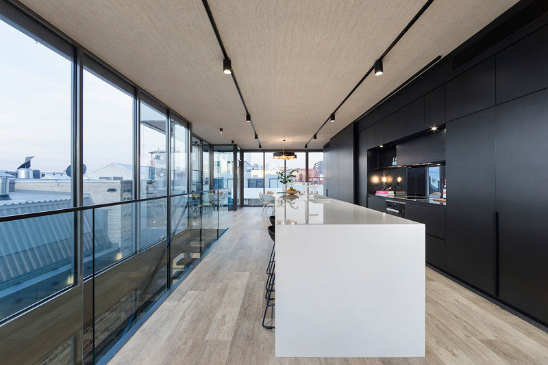 The long black wall of cabinetry runs the entire length of the top floor of this home, from the living room to the kitchen to the dining room.