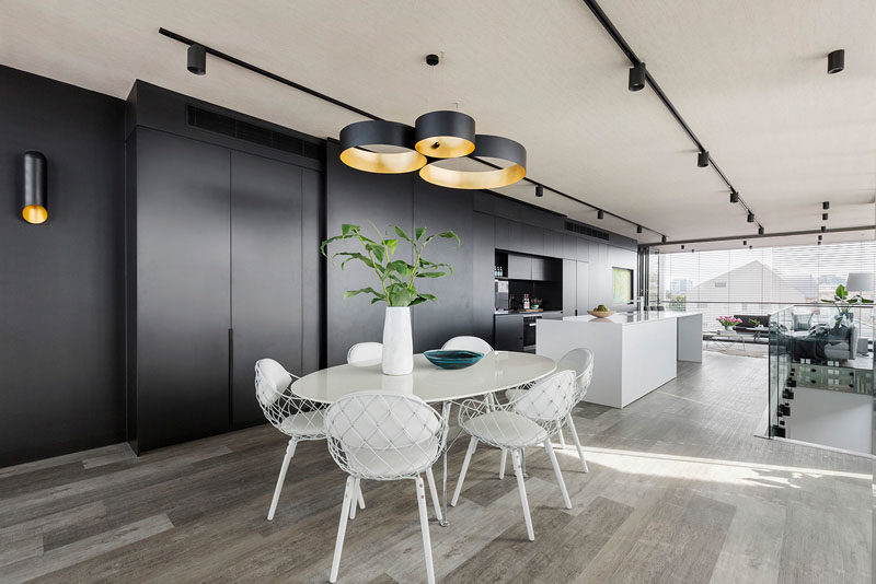 The white dining table matched the white kitchen island, and the black and gold pendant light matches the black and gold sconce on the wall.