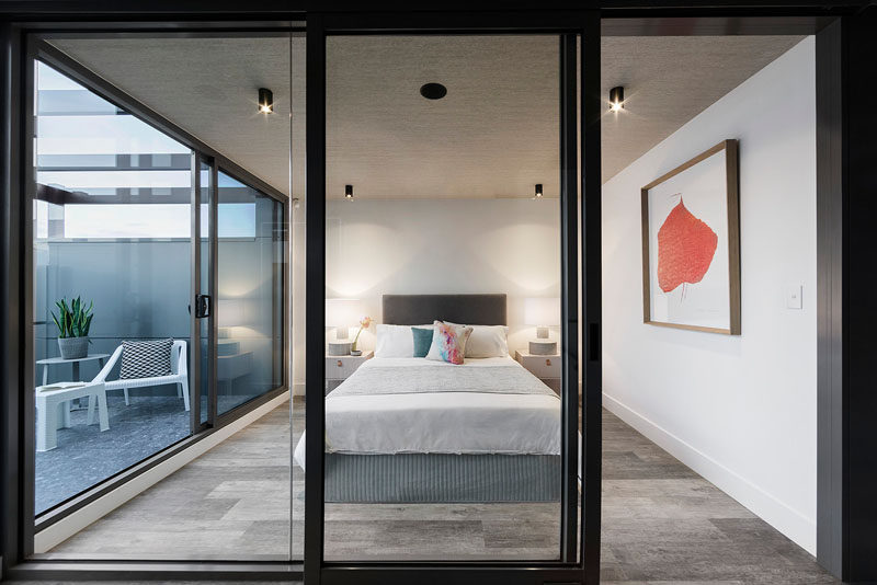 This bedroom has glass walls that allow plenty of light into the room, and there's a small private balcony to the side.