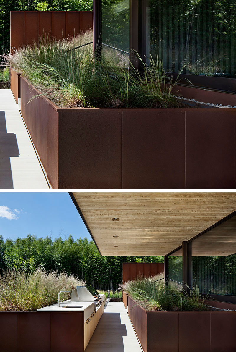 9 Ideas For Including Weathering Steel Planters In Your Garden // Huge planters fill the backyard patio of this family home, and make dinner parties feel like they're taking place in the well-groomed great outdoors. #SteelGardenPlanters #WeatheredSteelPlanters #CortenSteelPlanters #Landscaping #GardenIdeas #PlanterIdeas