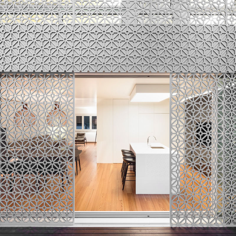 The rear of this house is covered in a white artistic screen inspired by traditional Portuguese tiles, to allow sunlight to filter through to the interior of the home and to provide added security.