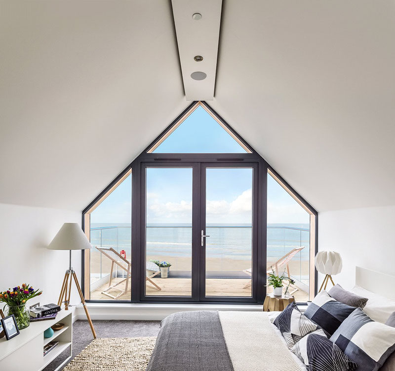 15 Awesome Examples Where Windows Follow The Roofline // This window takes up the entire wall and fits snuggly into the angles of the roof and walls to offer incredible views of the beach and ocean even from the bed.