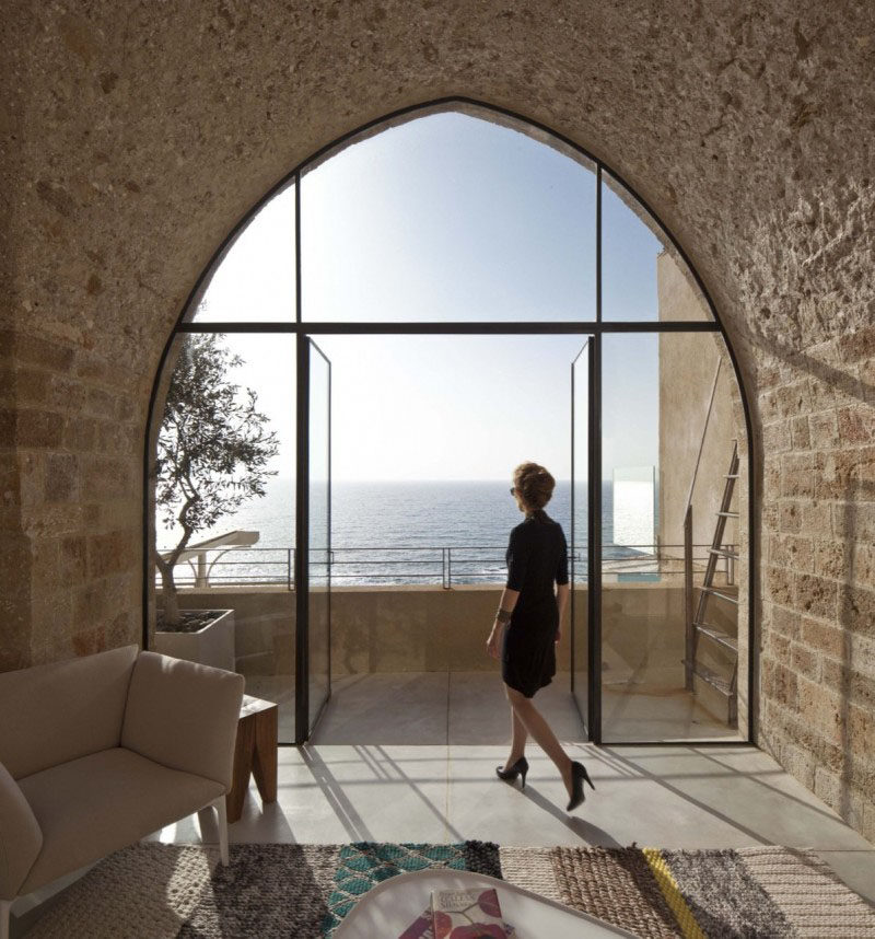 15 Awesome Examples Where Windows Follow The Roofline // This modern curved window fits perfectly into the old stone of this historic apartment building in Jaffa, Isreal and almost creates an art piece out of the sea behind it.