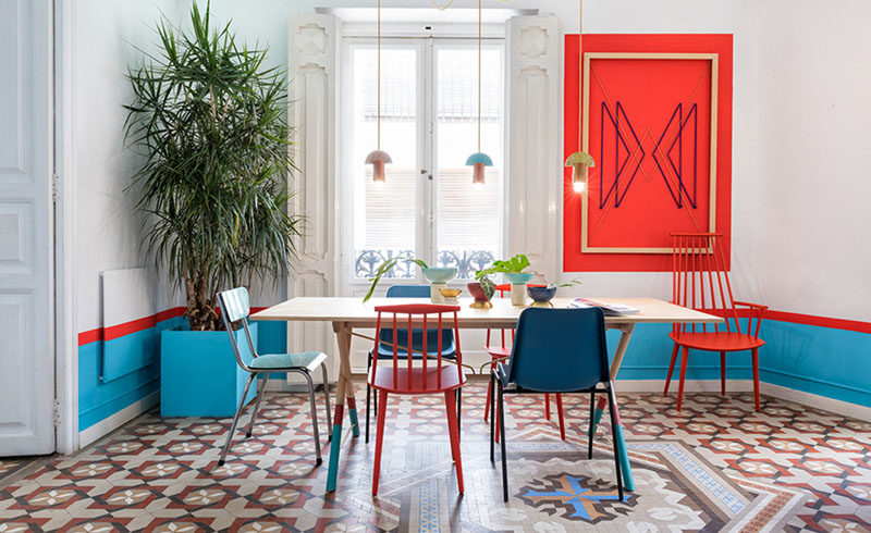 Wall Decor Inspiration - Bold Graphics Cover The Walls Of This Spanish Hostel // In this room, red artwork ties in with the red stripe around the room and red chairs.