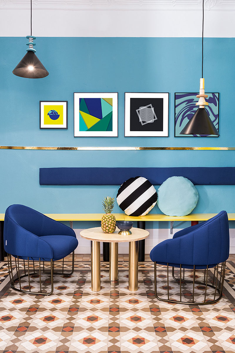 Wall Decor Inspiration - Bold Graphics Cover The Walls Of This Spanish Hostel // Various shades of blue are broken up by artwork and gold/yellow touches.