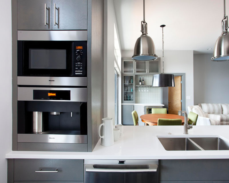 9 Examples Of Kitchens With Built-In Coffee Machines // The black elements of the stainless steel bodied built in coffee machine work with the dark grey cabinetry in this contemporary kitchen.