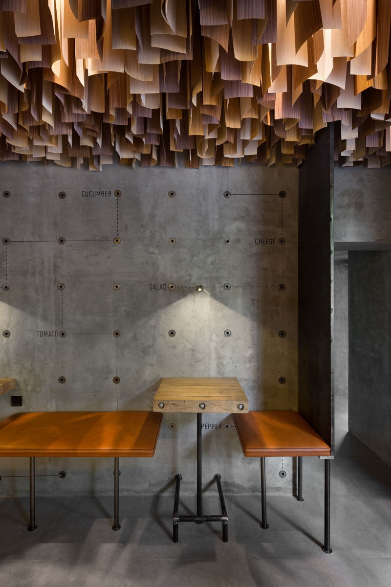 This Ukrainian burger bar has an artistic ceiling detail made from hundreds of wood veneer sheets.