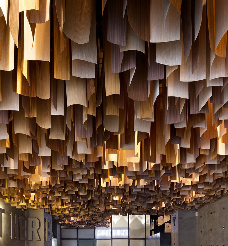 This Ukrainian burger bar has an artistic ceiling detail made from hundreds of wood veneer sheets.